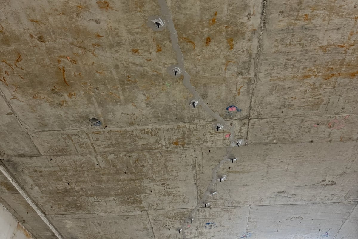 Low-viscosity epoxy resin injection into overhead suspended slab cracks